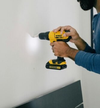 person holding yellow and black cordless hand drill