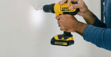 person holding yellow and black cordless hand drill