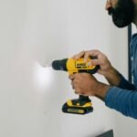 person holding yellow and black cordless hand drill